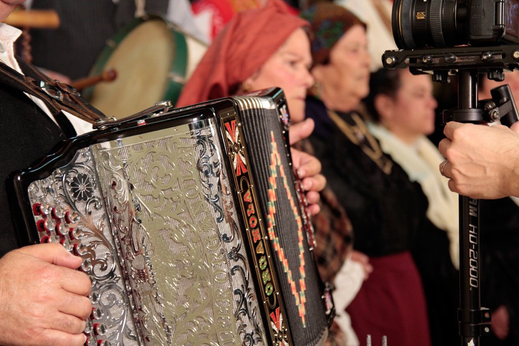 Acordeão a ser tocado junto de cantadeiras de traje tradicional, durante a gravação