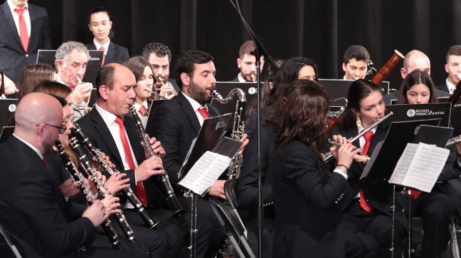 Banda filarmónica em concerto, com clarinetes e partituras