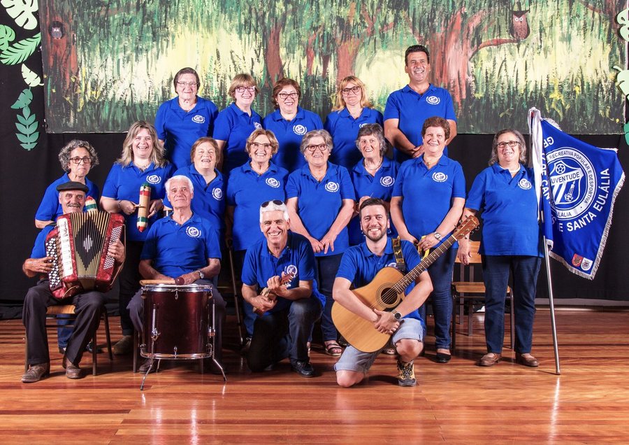 Grupo de Cantares de Santa Eulália posado em palco, com a sua bandeira