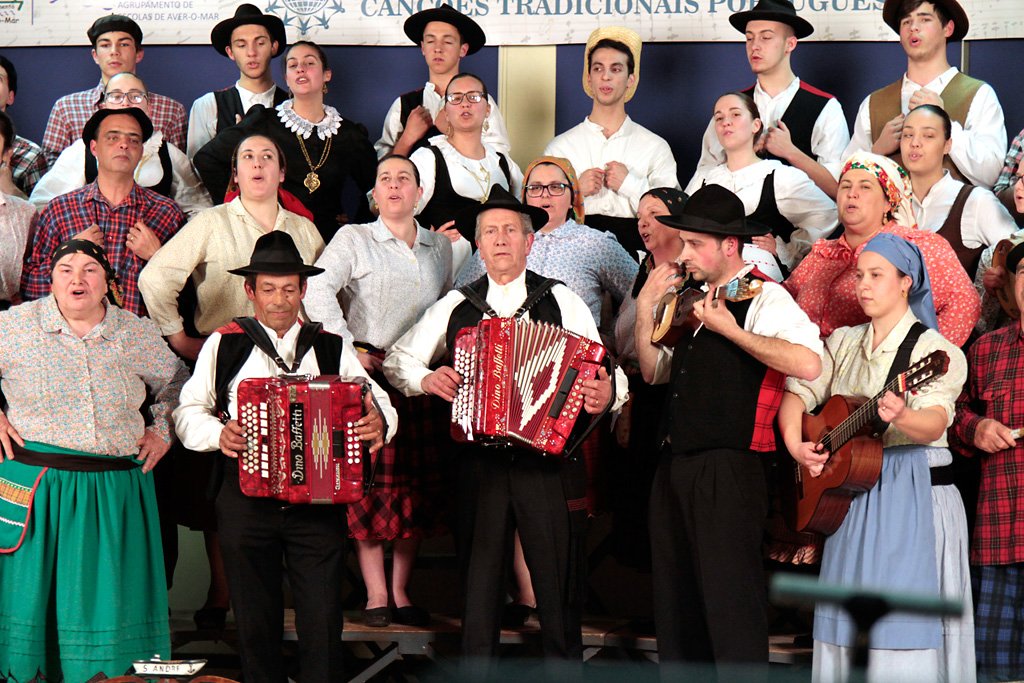 Grupo de trajes regionais a tocar acordeões e cantar em conjunto
