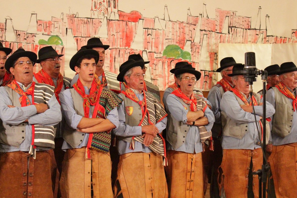 Grupo de cantares tradicionais, de lenço vermelho ao pescoço, a cantar em palco