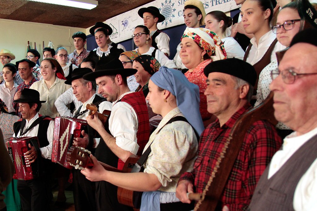 Tocadores de acordeão e viola, em trajes regionais, durante a atuação